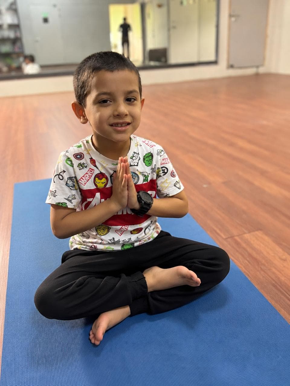 Child in a calm yoga namaste pose
